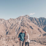 Couple in the the beautiful landscape around Gergeti Trinity Church, Georgia www.atasteoffun.com